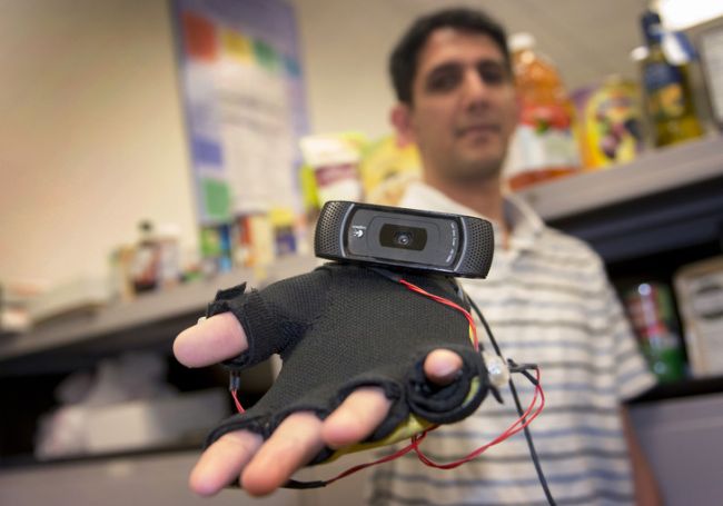 Graduate student Siddharth Advani displays the webcam-equipped haptic glove he helped design as part of the Third Eye: Visually Impaired project.